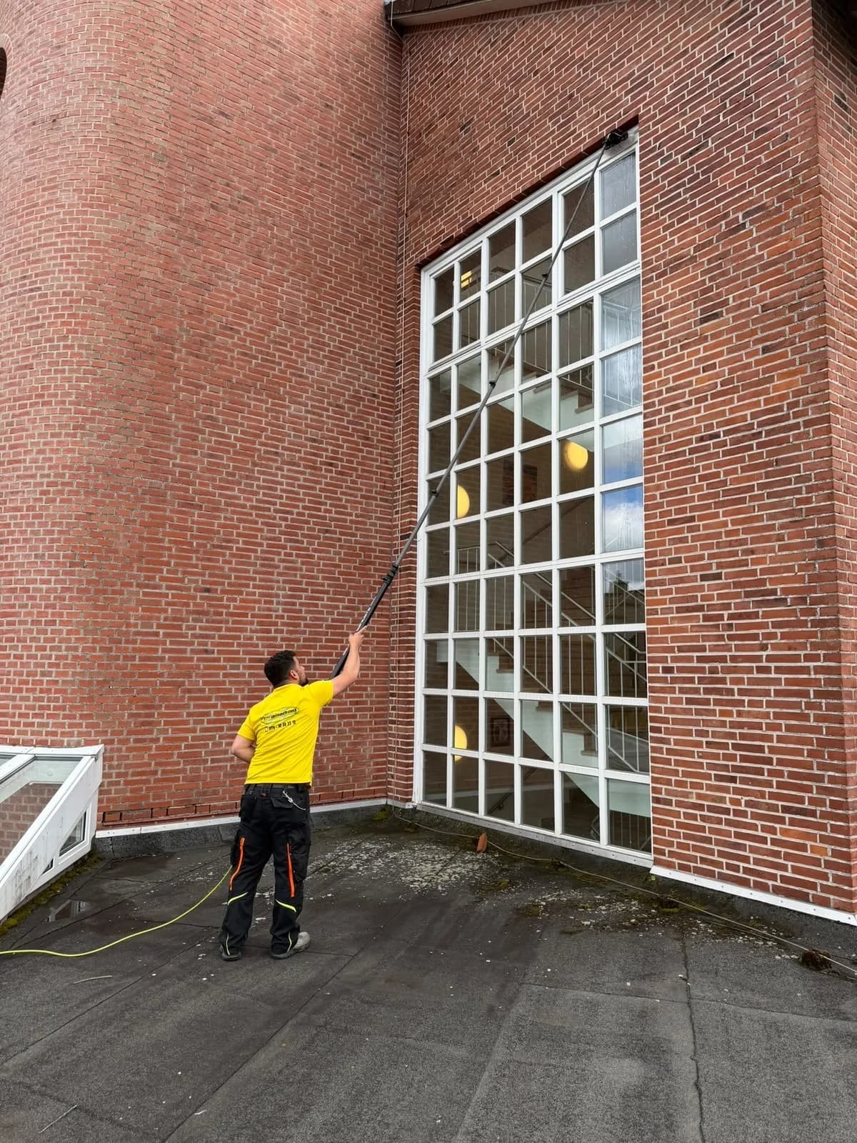 Fensterreinigung mit Rahmen an einer Glasfassade in Kiel mit Reinwasser-Teleskopstange
