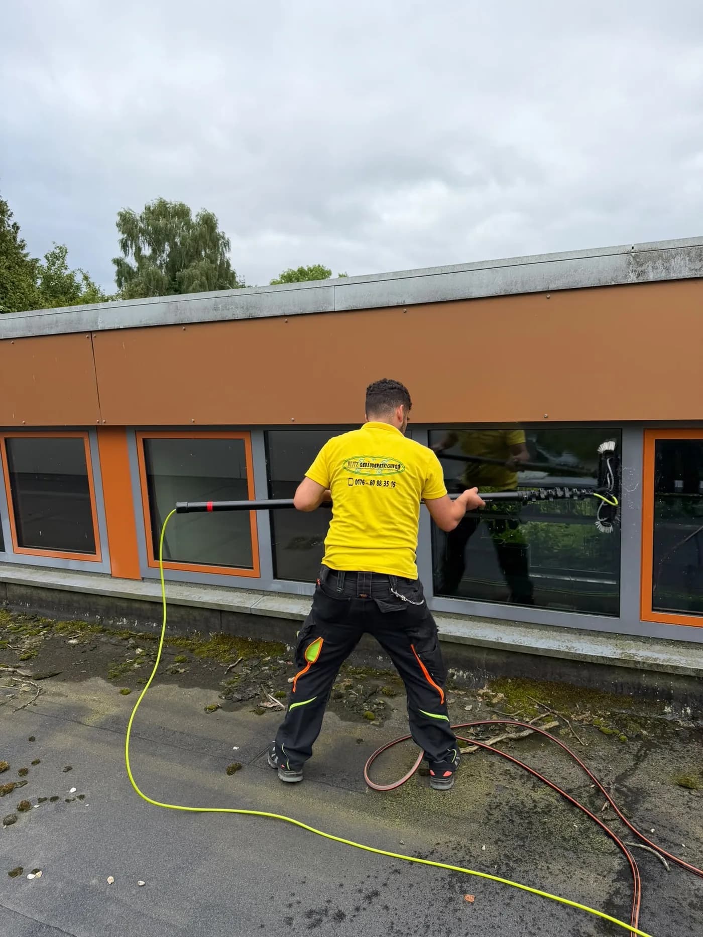Mitarbeiter der Blitz Gebäudereinigung bei der Hochdruckreinigung eines Flachdachs