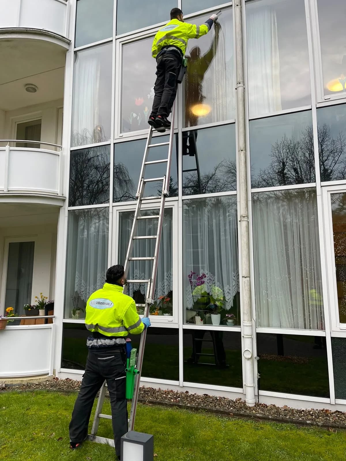 Fensterreinigung mit Rahmen an einer Glasfront durch die Blitz Gebäudereinigung
