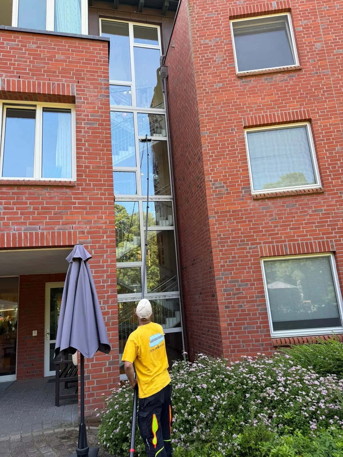 Mitarbeiter der Blitz Gebäudereinigung bei der Fassaden- und Fensterreinigung an einem Wohnhaus in Schwerin