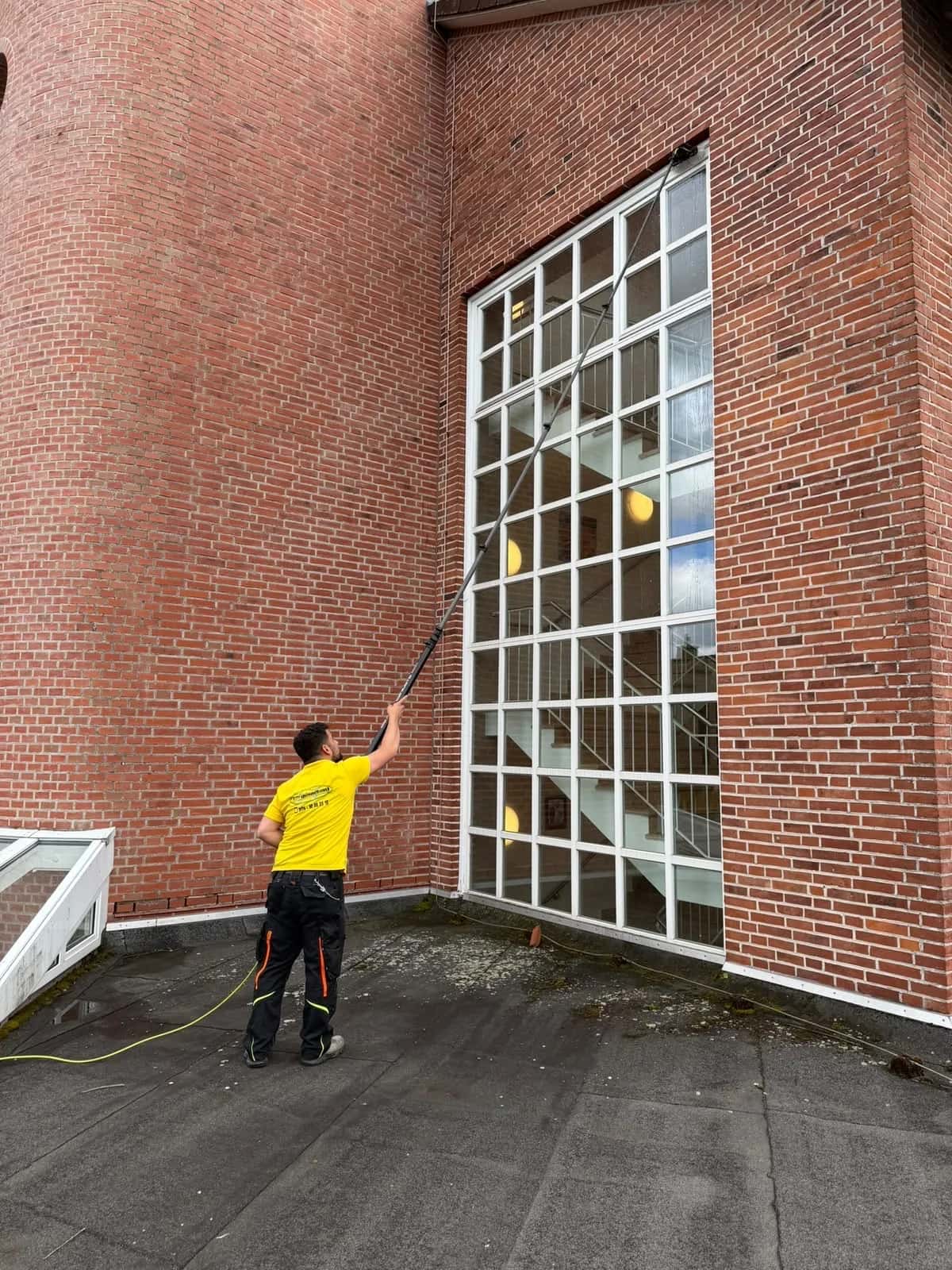 Fensterreinigung mit Rahmen an einer Glasfassade in Kiel mit Reinwasser-Teleskopstange
